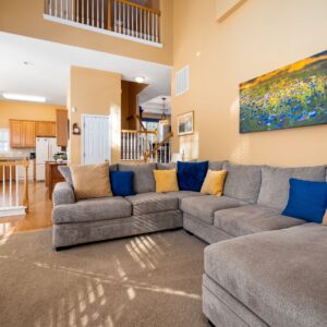 Bright and spacious living room showcasing a cozy grey sofa and modern interior design.